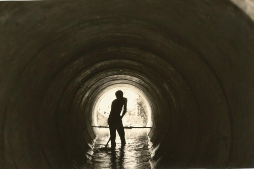 Worker in a tunnel water piping system